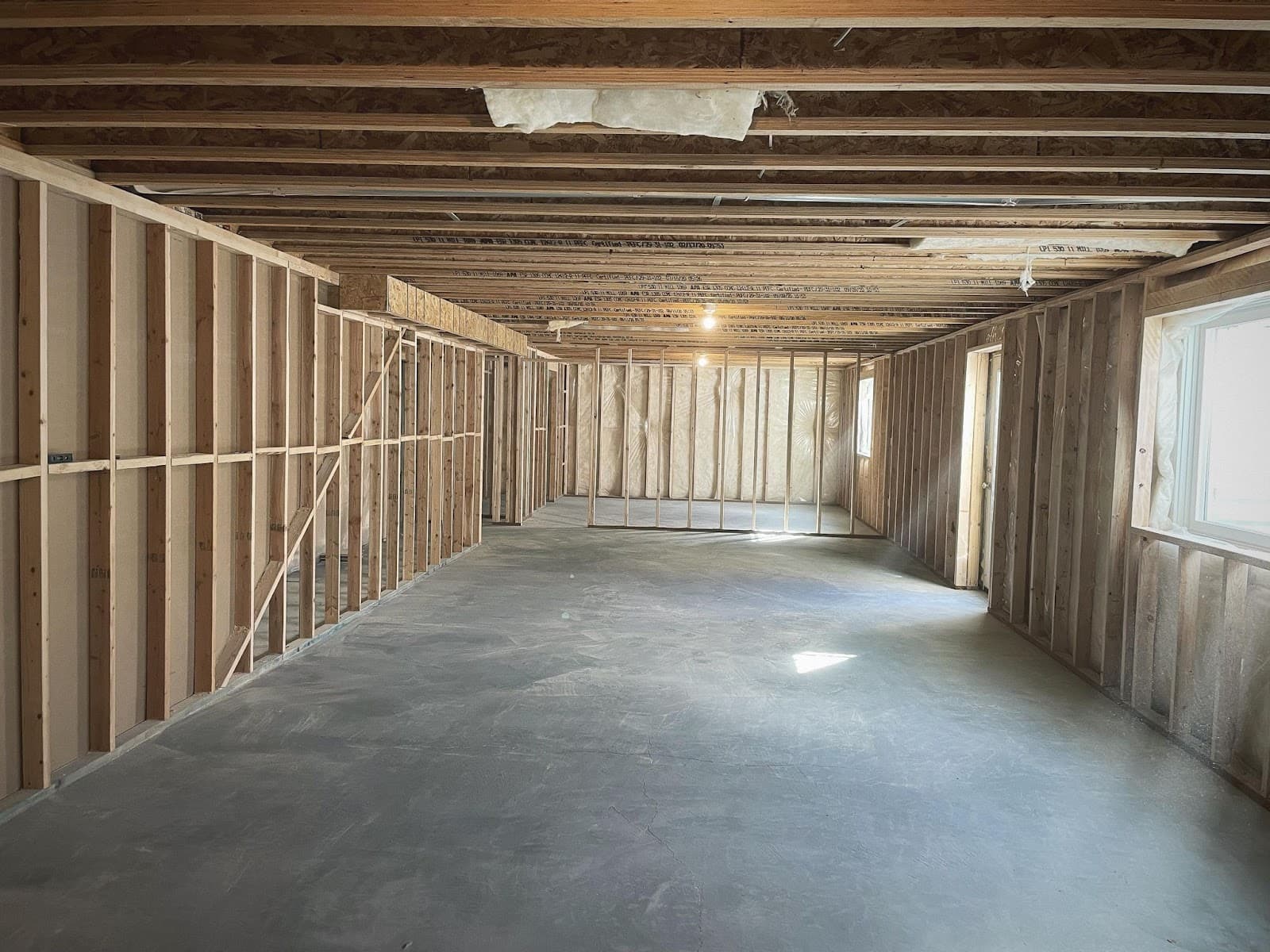 Basement framing in progress in a Davis County home, new walls laid out over concrete