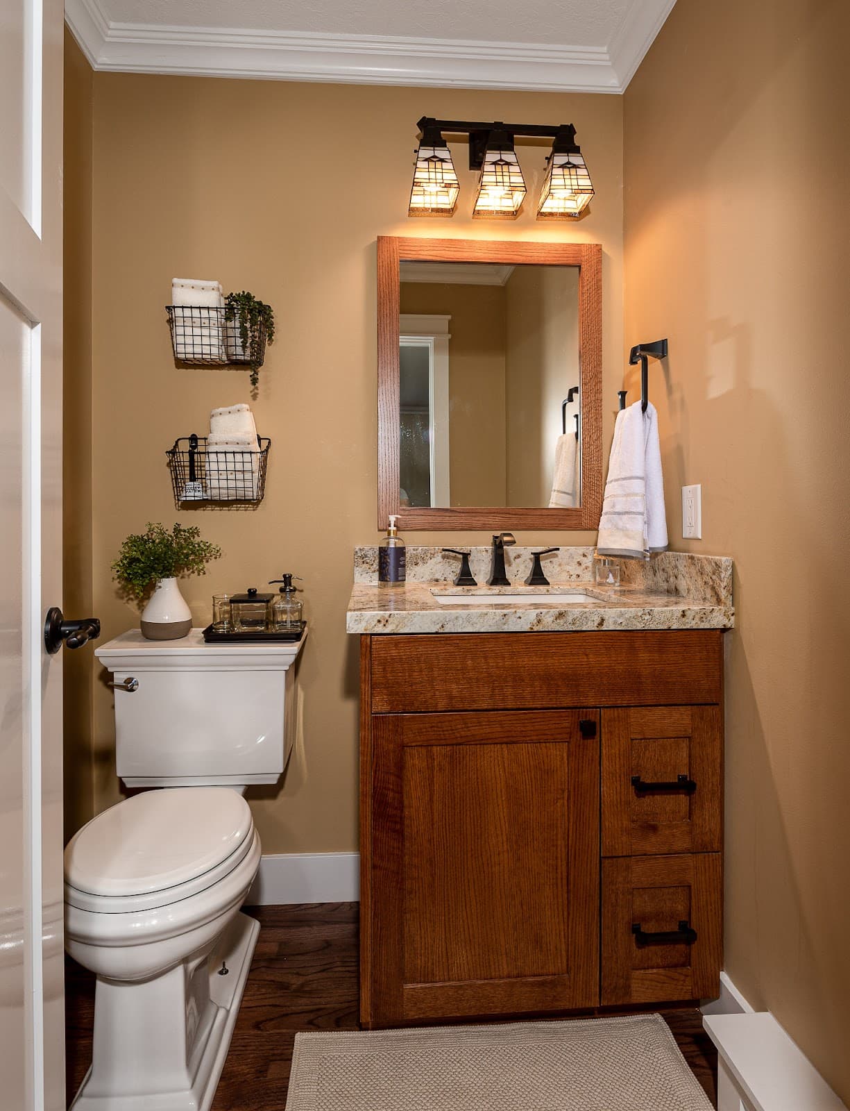 Remodeled bathroom with wood vanity, granite top, and updated lighting