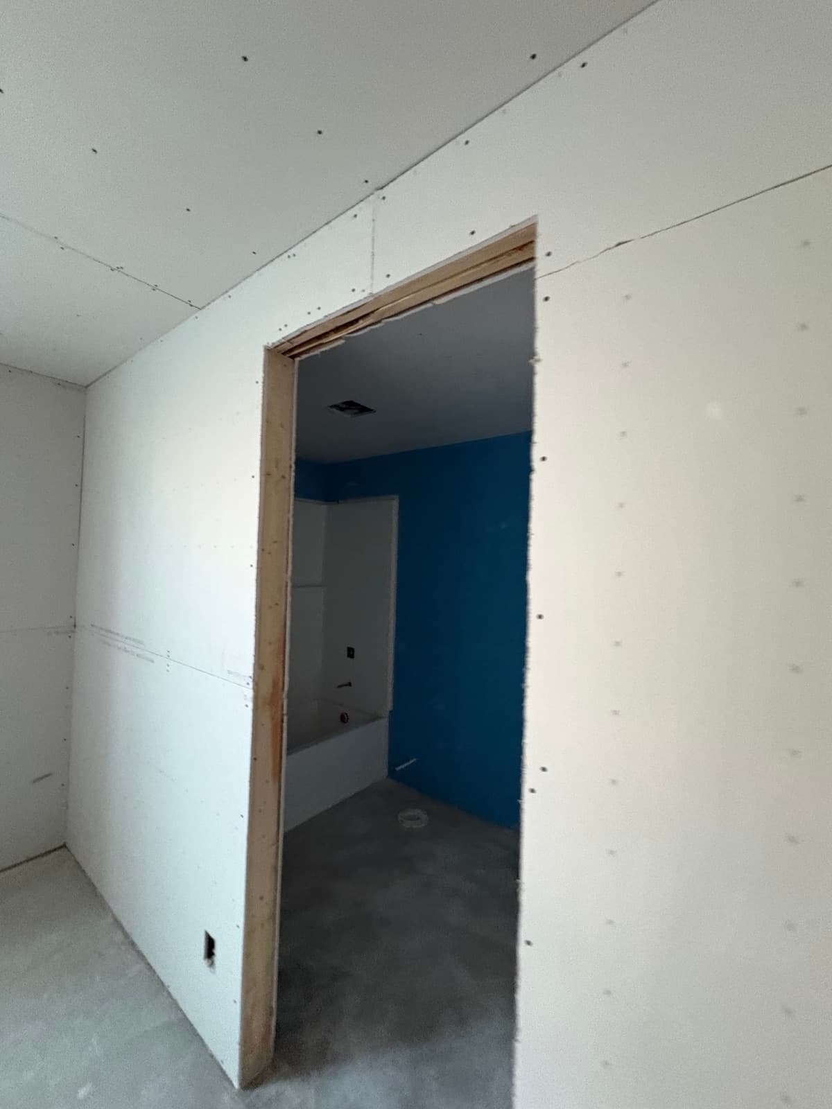 Doorway into the basement bathroom with new drywall