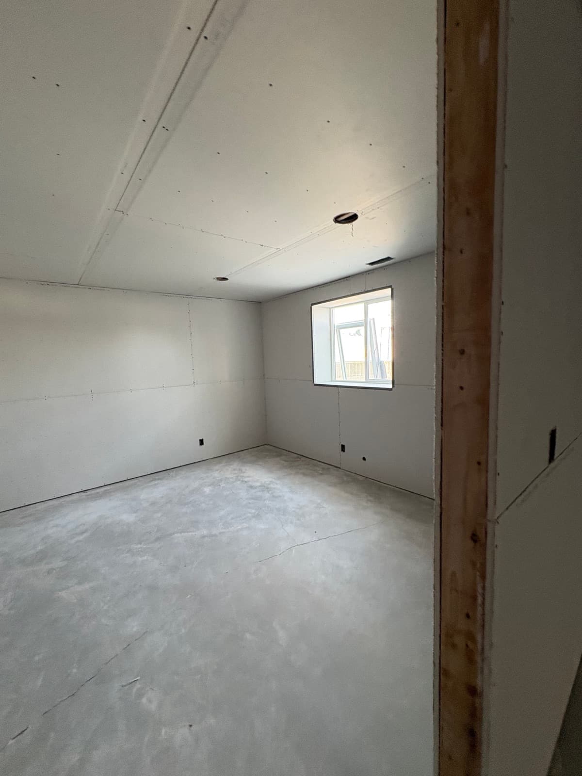 Basement bedroom with egress window, drywall hung