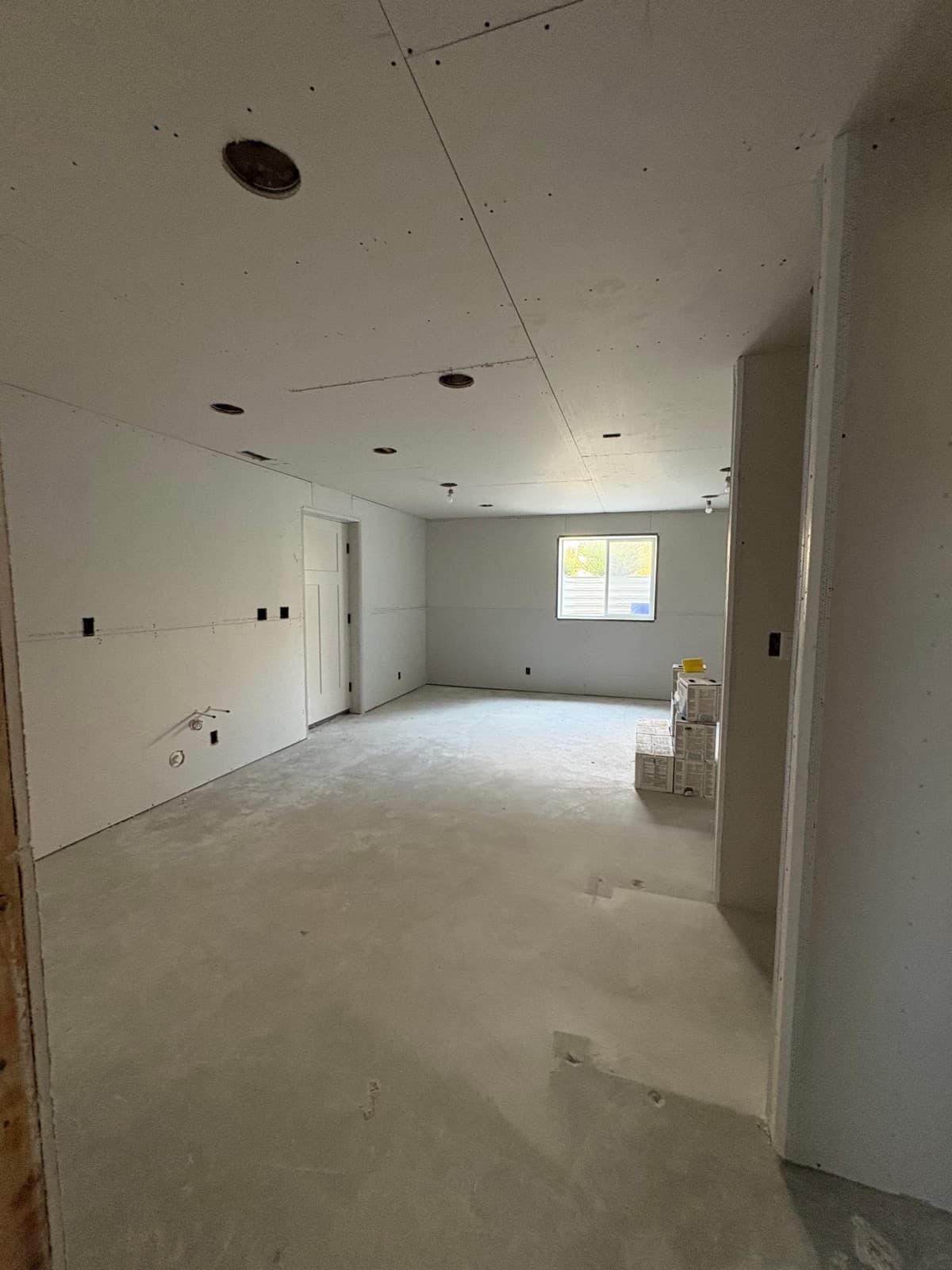 Clinton basement family room with drywall hung on walls and ceiling, before tape and mud