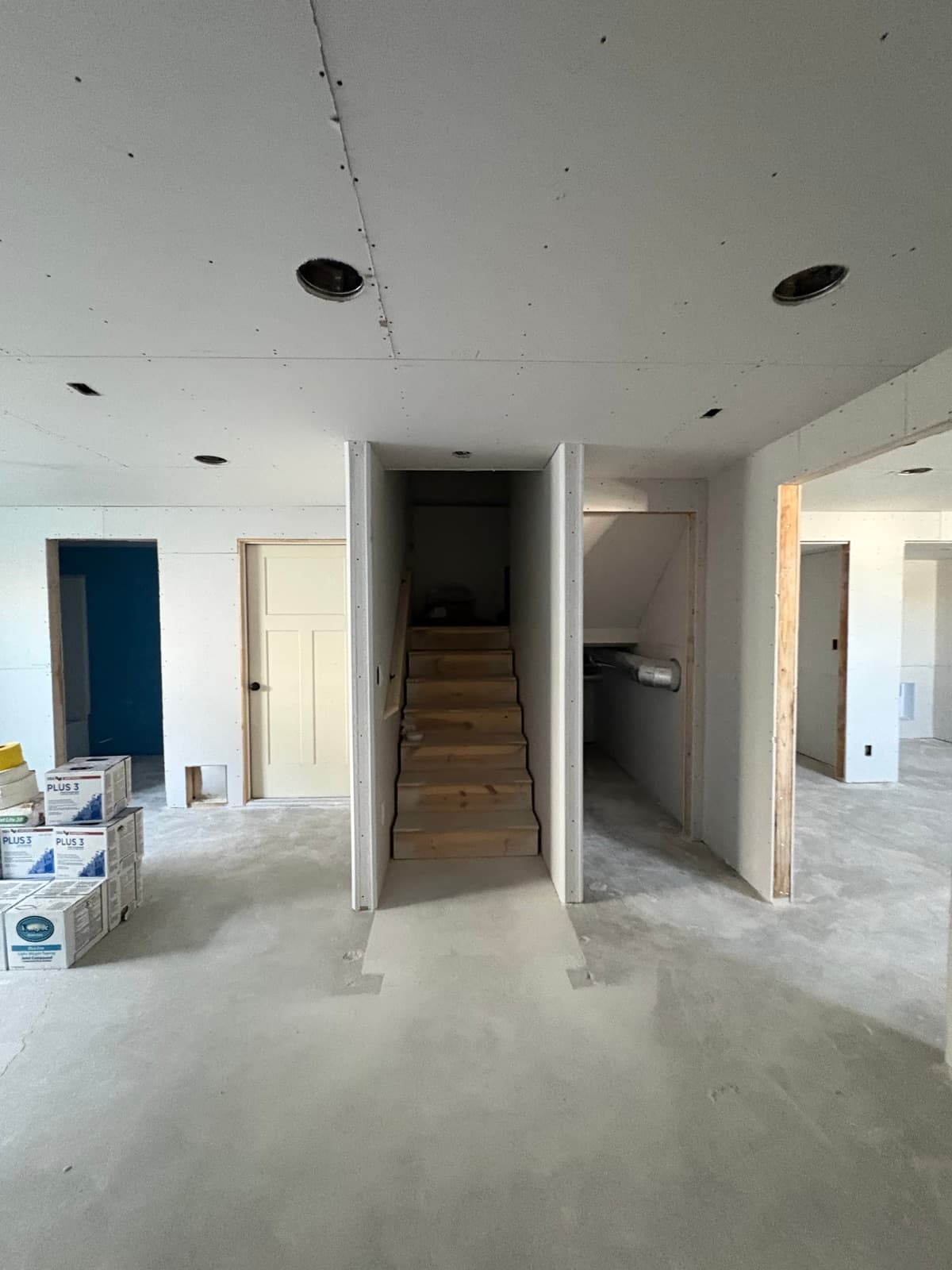 Stairwell walls and under-stair storage drywalled in the Clinton basement