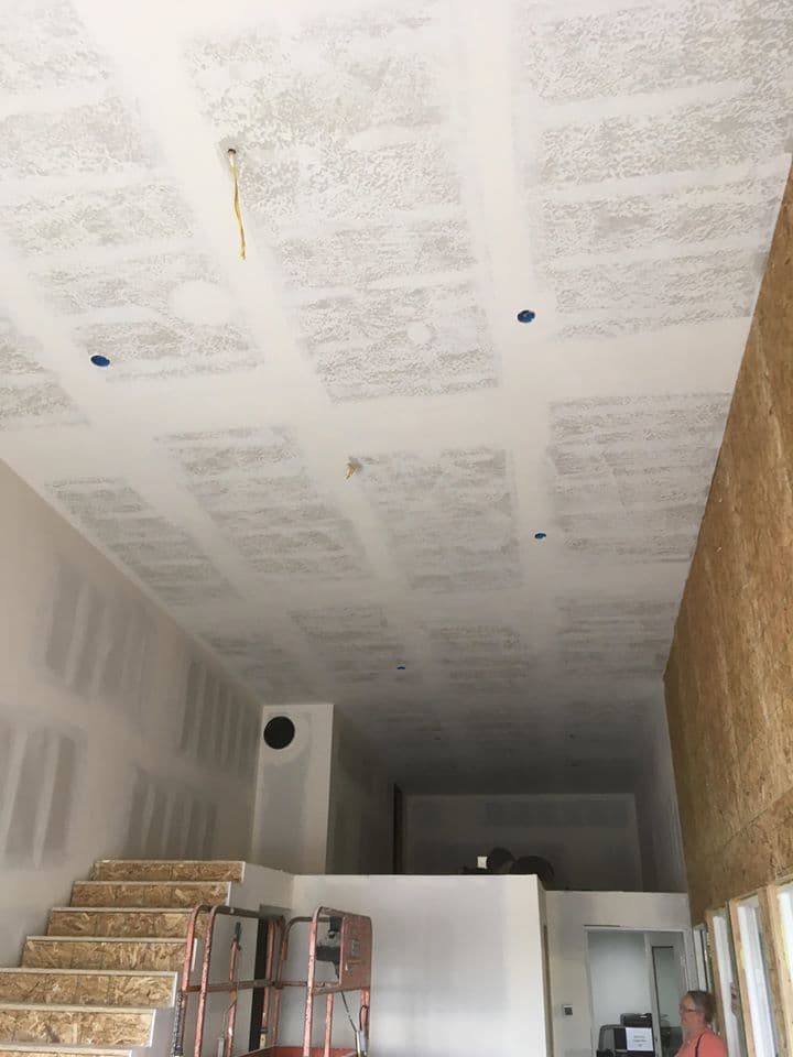 Taped and mudded drywall ceiling in progress before texture