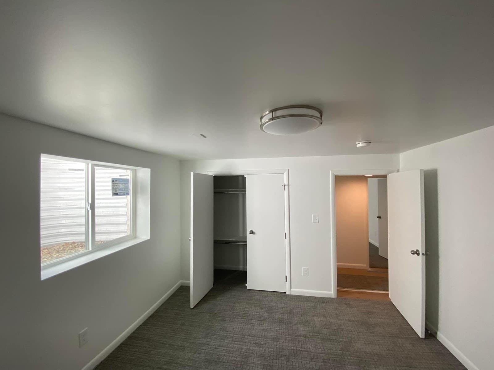 Finished basement bedroom with new carpet, closet, and trim by JS ProFinish