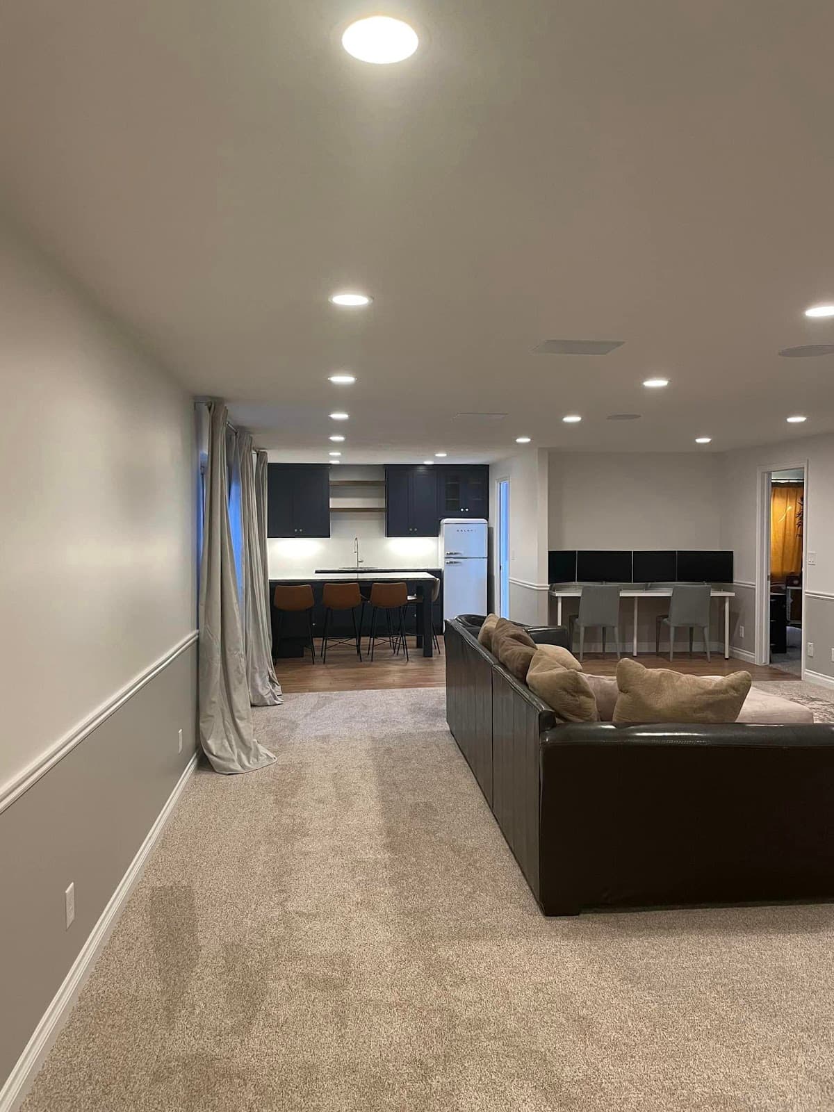 Finished basement by JS ProFinish with kitchenette, bar seating, and new carpet