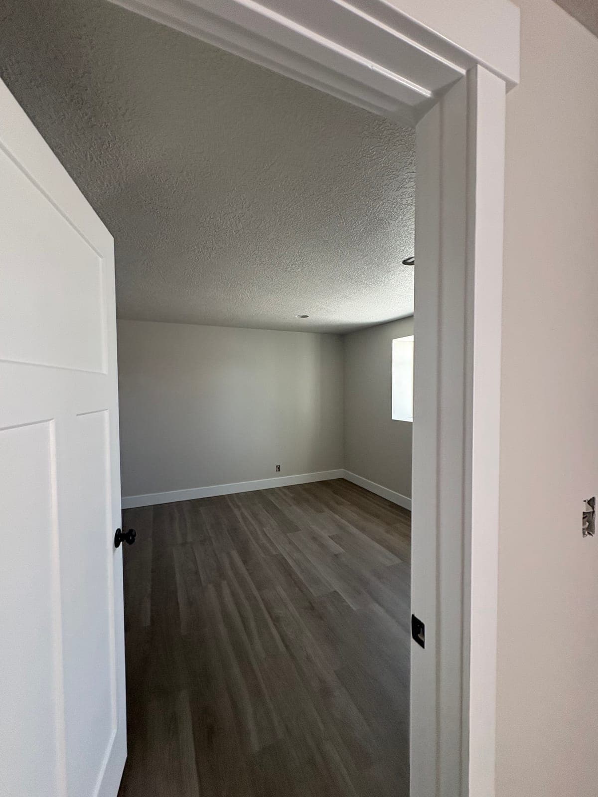 Finished bedroom doorway showing the two-tone paint: gray walls, white door and casing