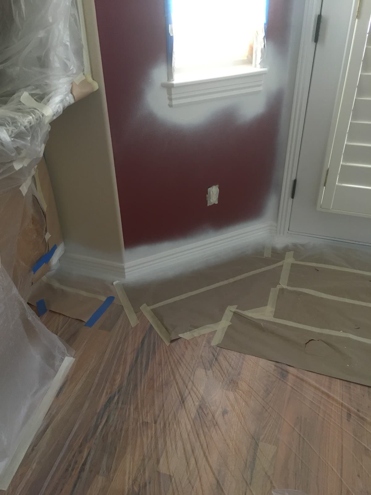 Deep red accent wall painted with crisp cut lines against white trim