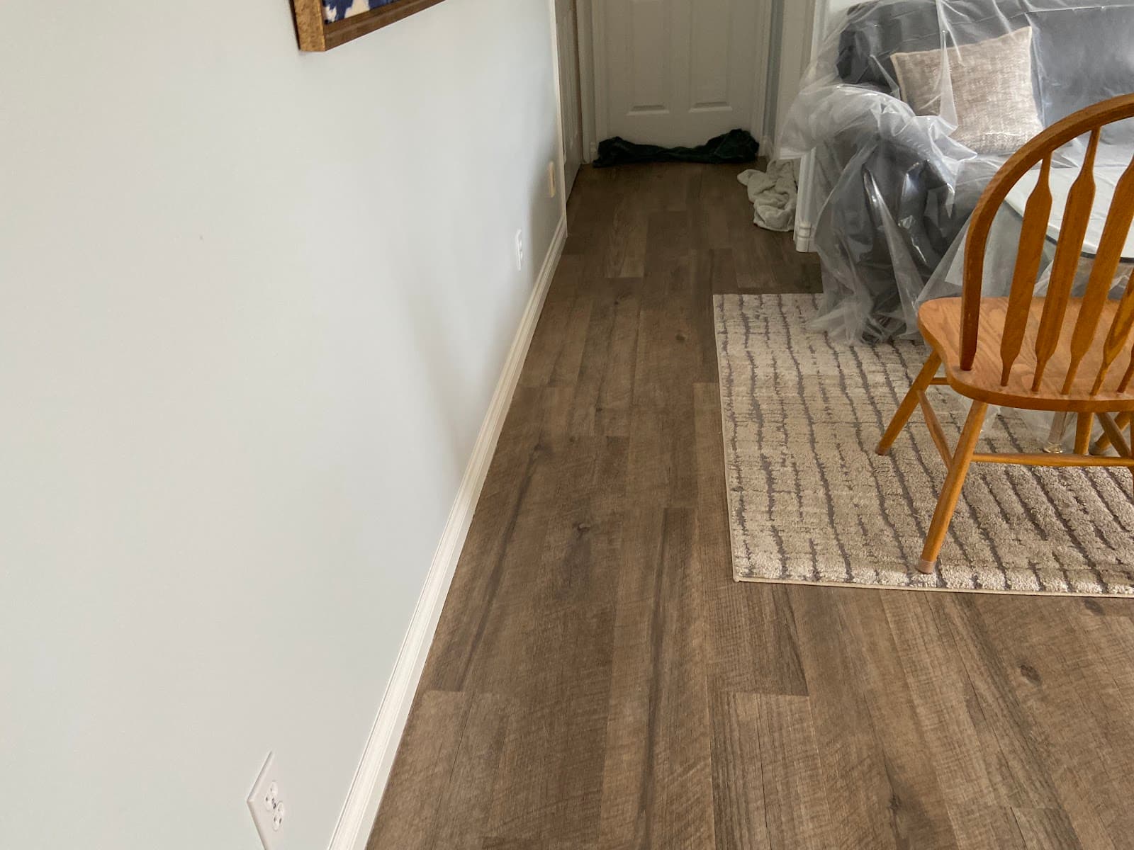 Finished room with new luxury vinyl plank flooring and white baseboards