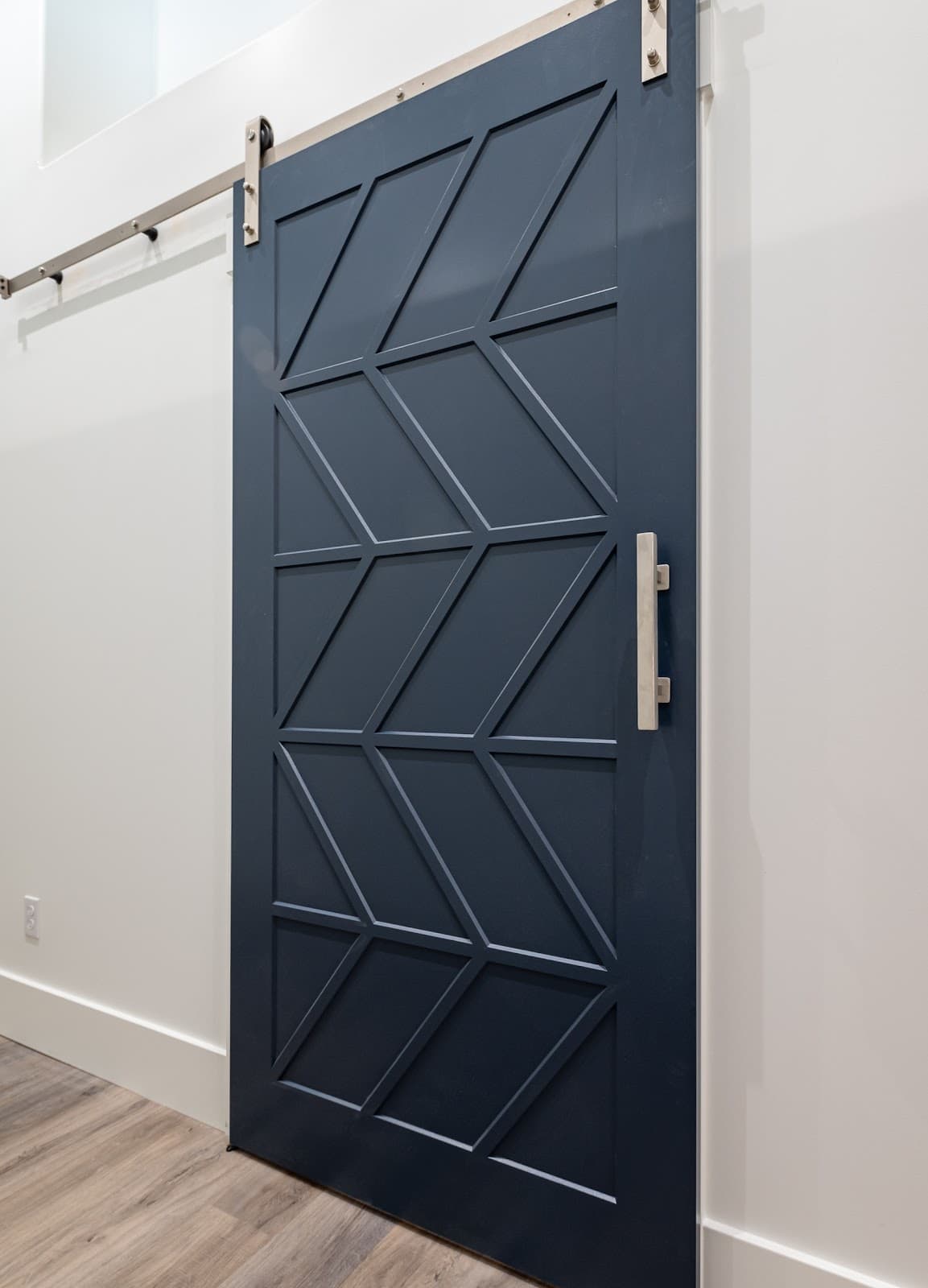 Navy blue barn door with custom geometric trim pattern