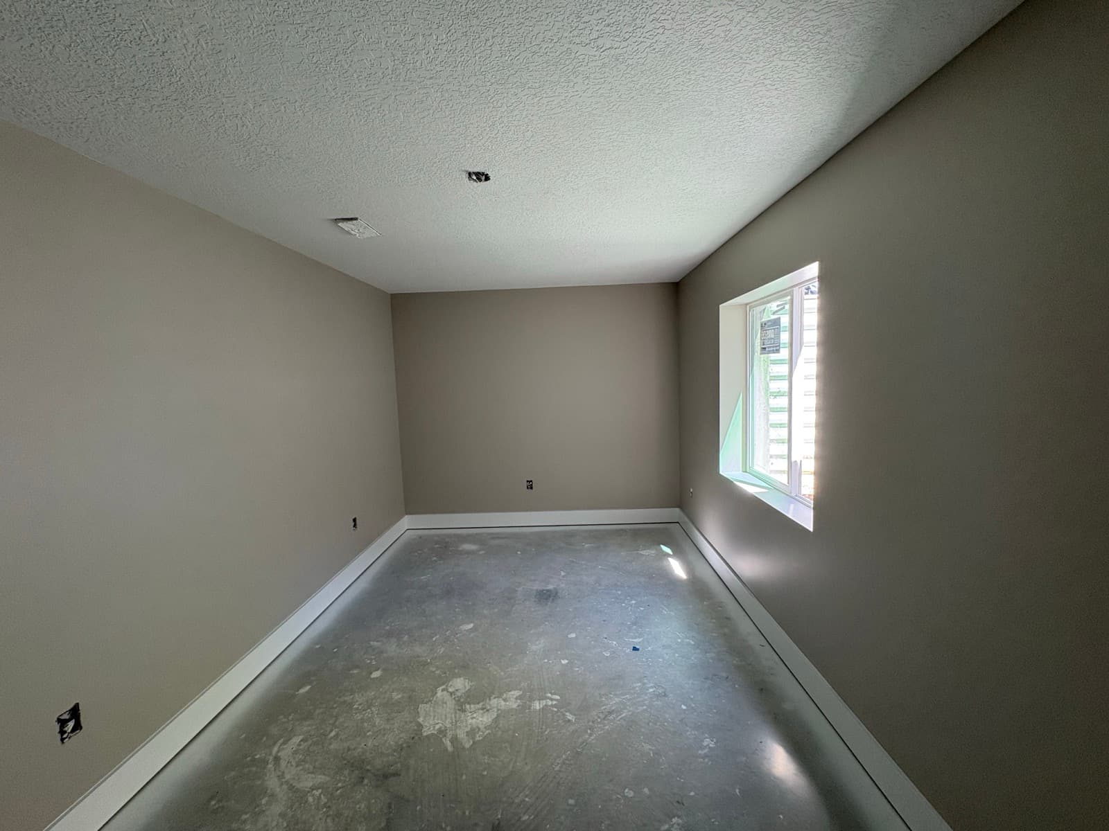 Painted basement room with new baseboard and door trim