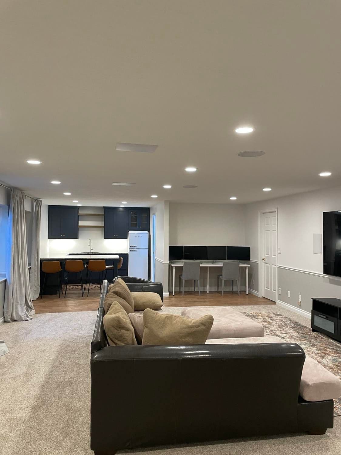 Basement kitchenette with dark cabinets and open shelving by JS ProFinish
