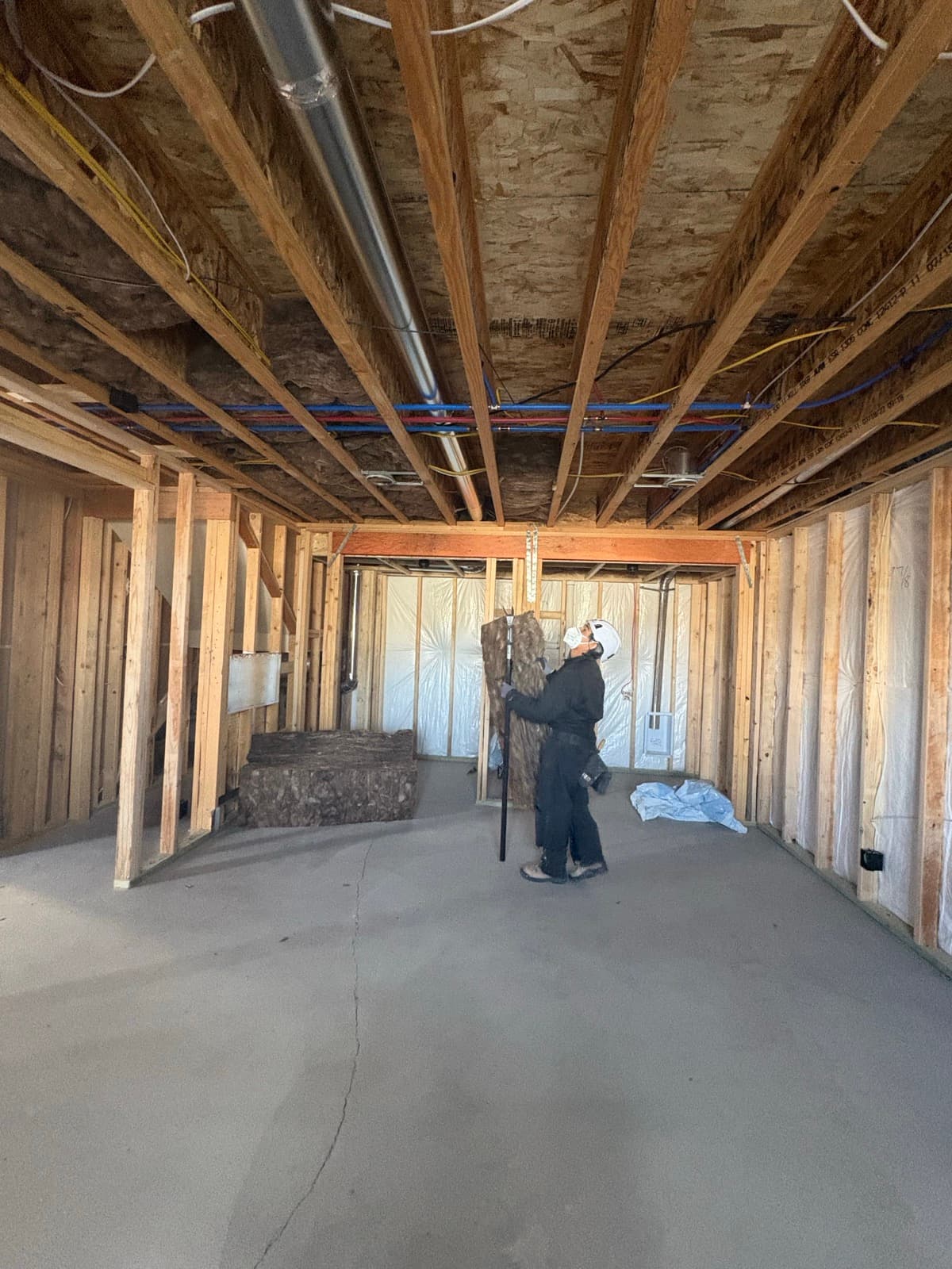 JS ProFinish crew staging lumber and prepping a basement for framing