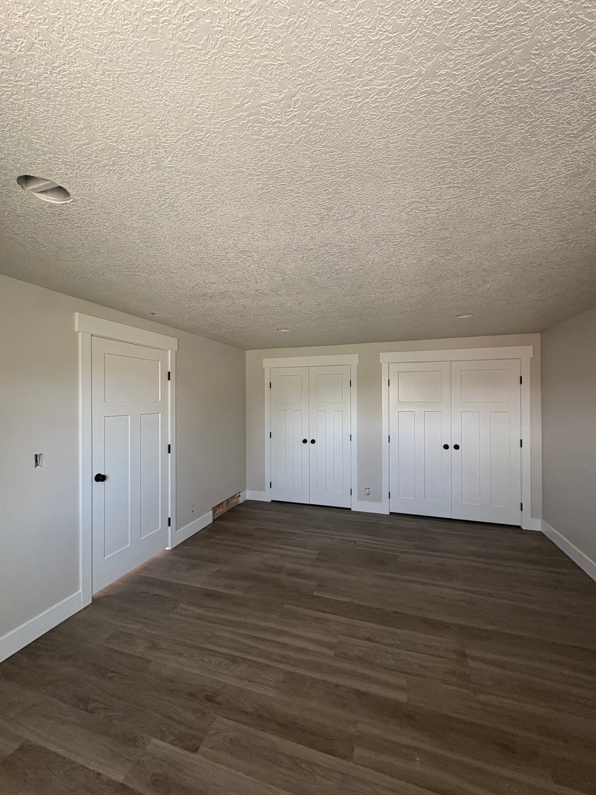 Finished basement bedroom in Clinton, Utah with bi-fold closets and two-tone paint, framed and finished by JS ProFinish