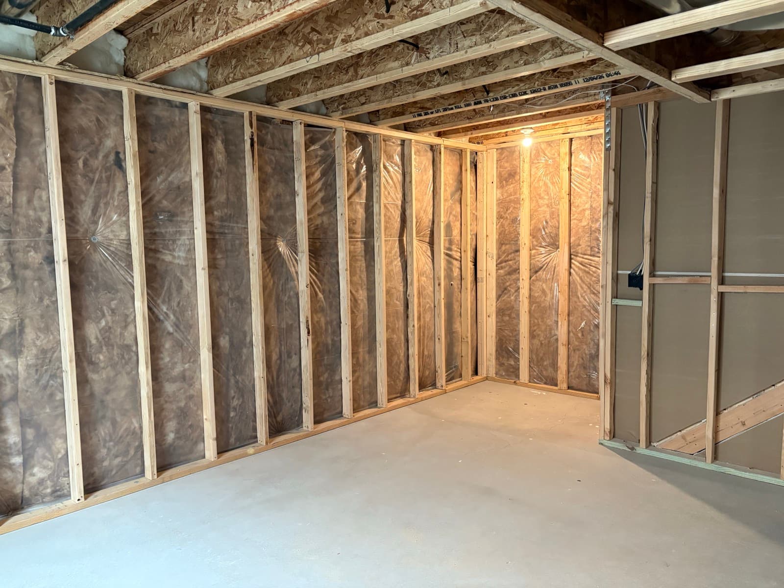 Framed basement walls with insulation installed, ready for drywall